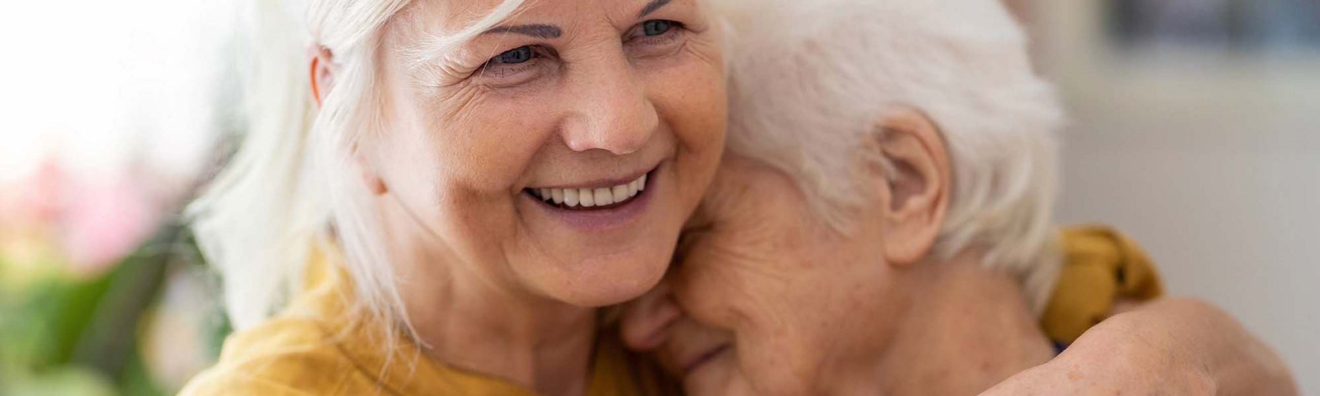 Frau hält ältere Frau im Arm